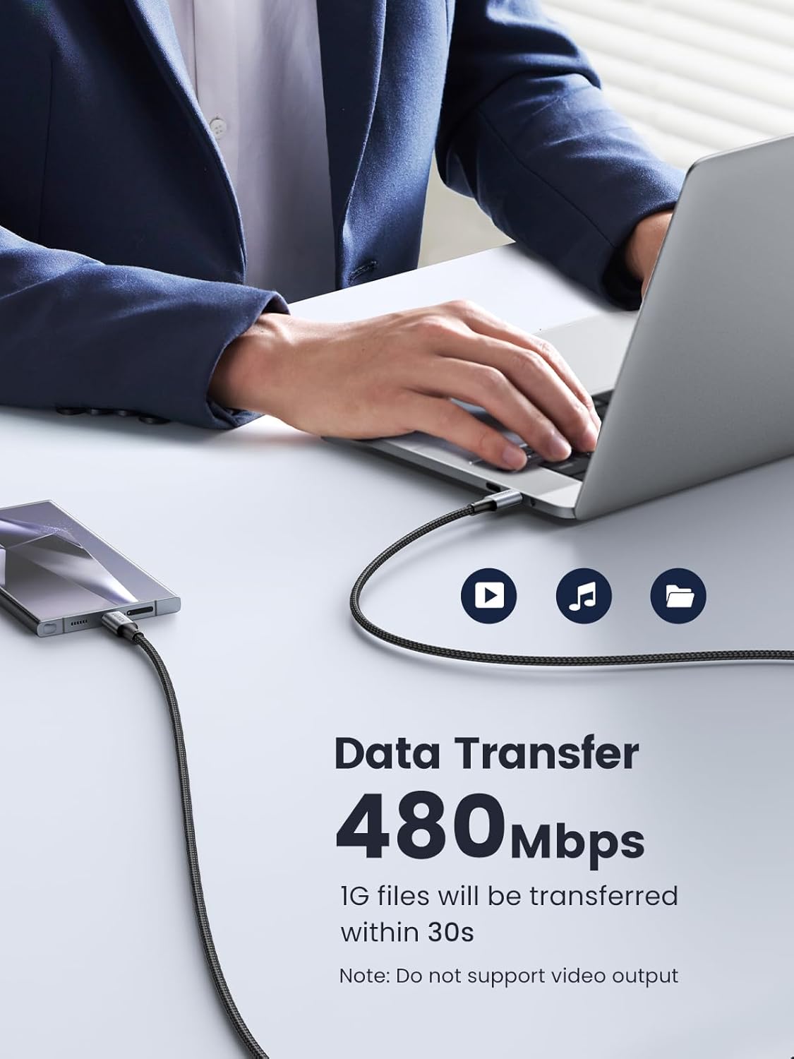 Person using a laptop with text about data transfer speed on a white desk.